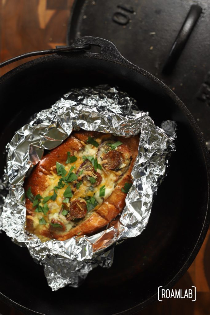 Freshly baked Egg Boat wrapped in tin foil in a cast iron dutch oven.