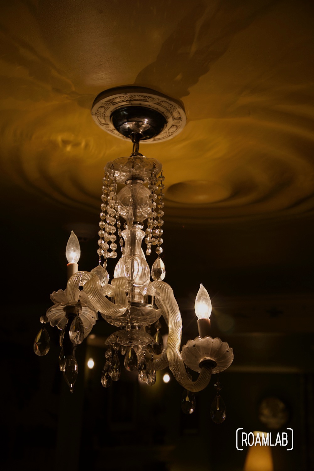 A melted chandelier hangs from a rippling ceiling in the House of Eternal Return, Meow Wolf's Santa Fe, New Mexico Location