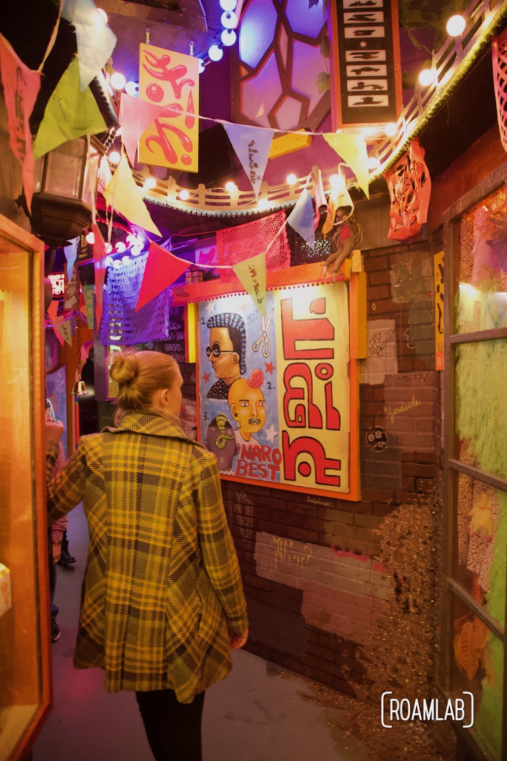 Woman walking down a colorful alley at the  House of Eternal Return, Meow Wolf's Santa Fe, New Mexico Location