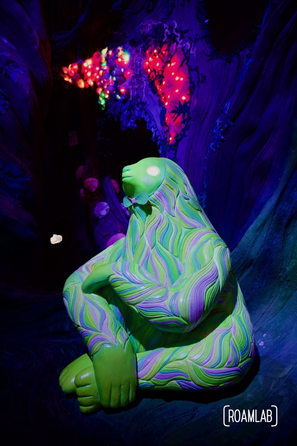 Psychedelic sloth sitting contemplatively in the colorful 6th dimensional world of Numina, part of Meow Wolf's Denver Colorado location, Convergence Station.