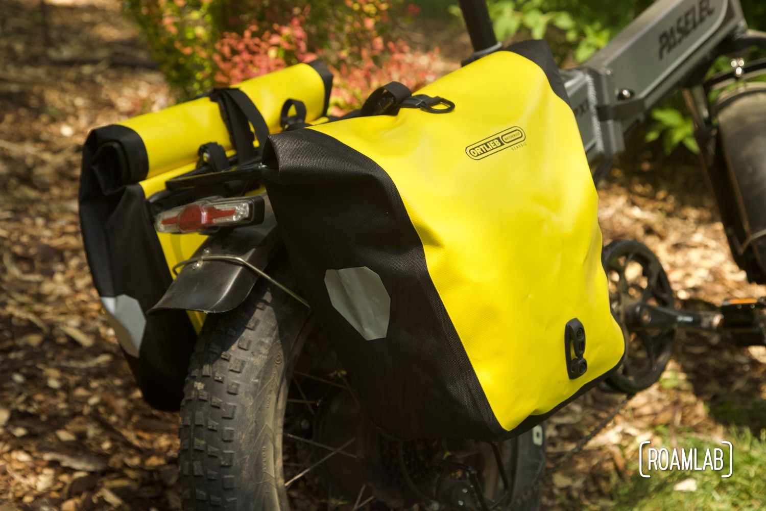 Bright yellow pannier bags mounted along the rear bicycle wheel.