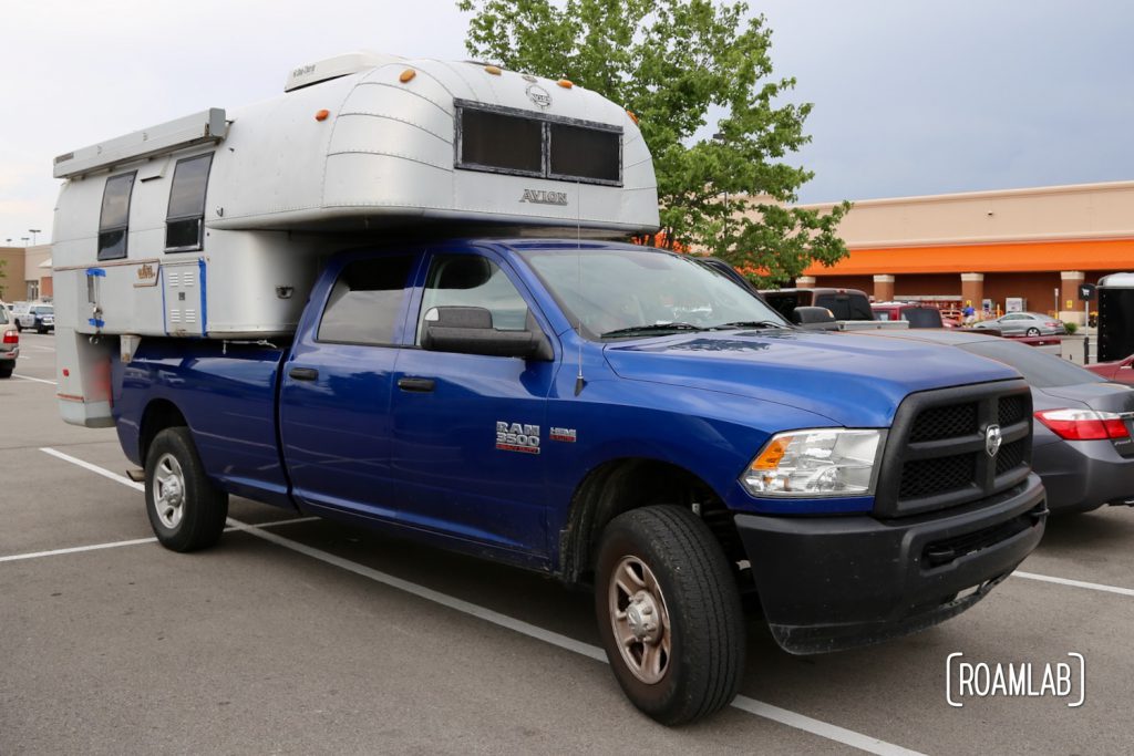 1970 Avion C11 truck camper on a blue 2016 Ram 3500 in a Home Depot parking lot.