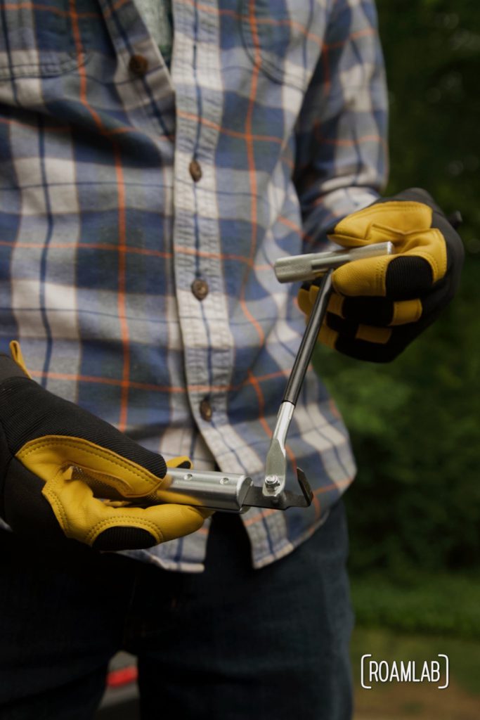 Gloved hands holding a windshield removal tool.