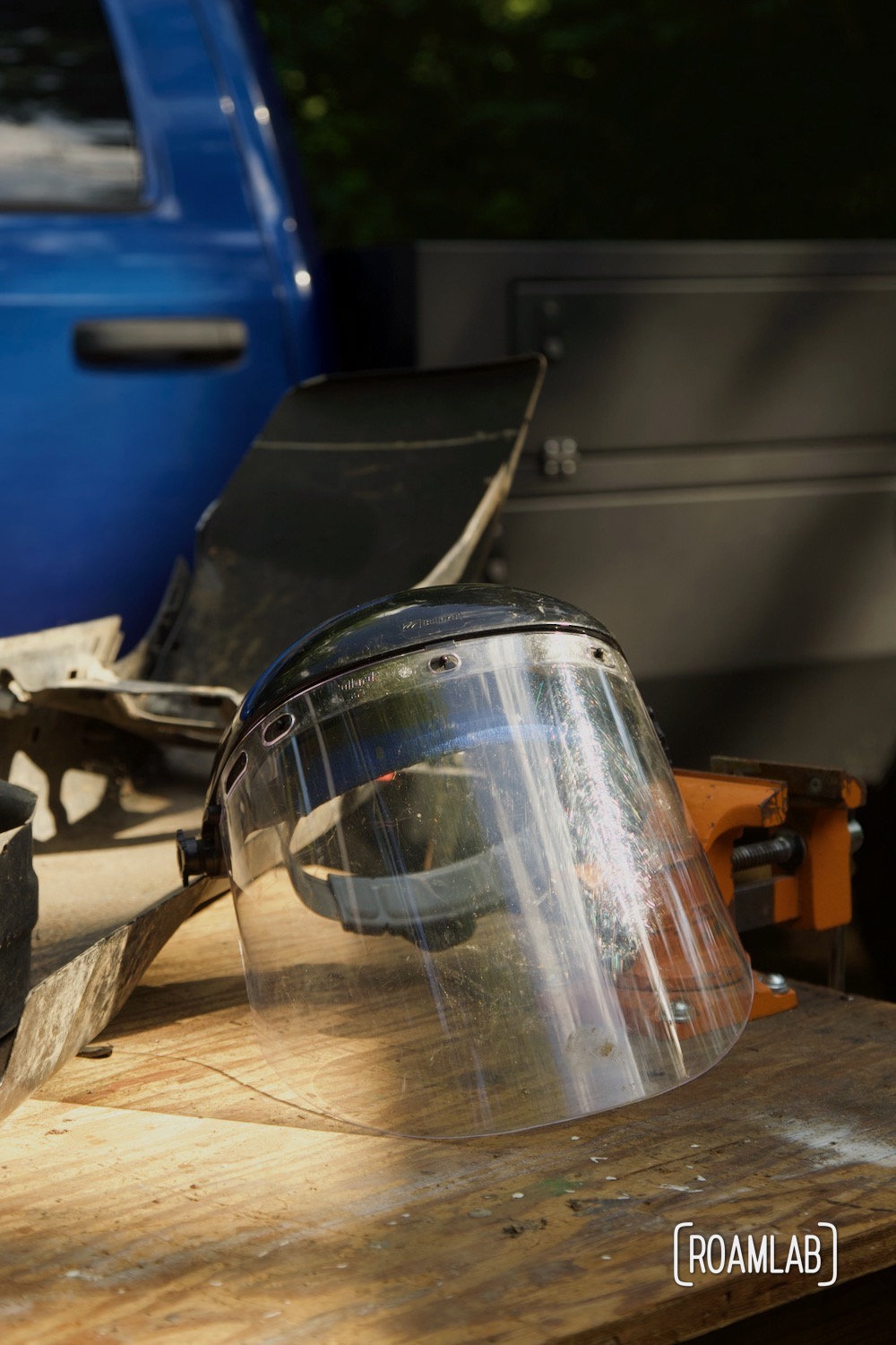 Face shield sitting on a wood work table.