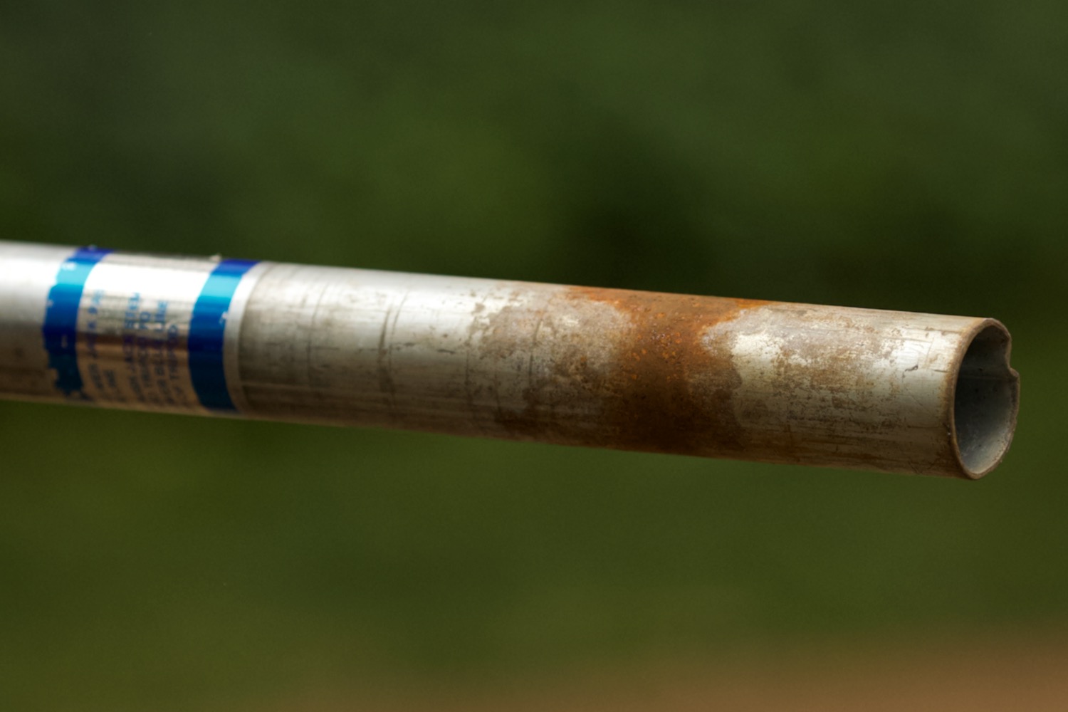 Closeup of a steel tube with a ring of corrosion.