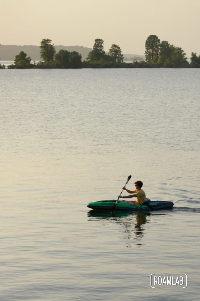 Man kayaking on a lake at sunset
