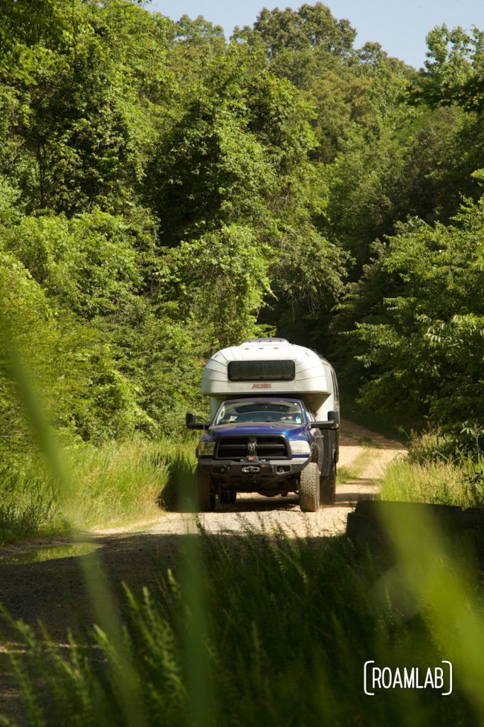Avion C11 truck camper driving down a rutted forest road in Land Between the Lakes National Recreation Area.