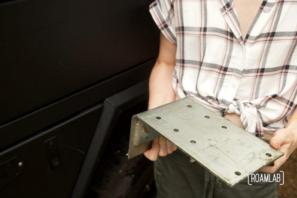 Woman holding steel bracket.