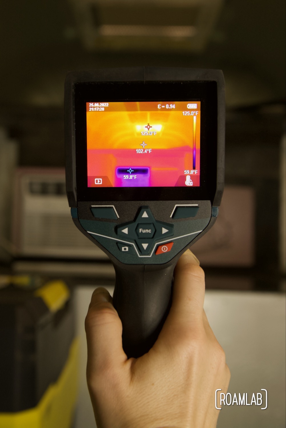 Hand holding a thermal camera revealing temperature extremes inside of a truck camper.