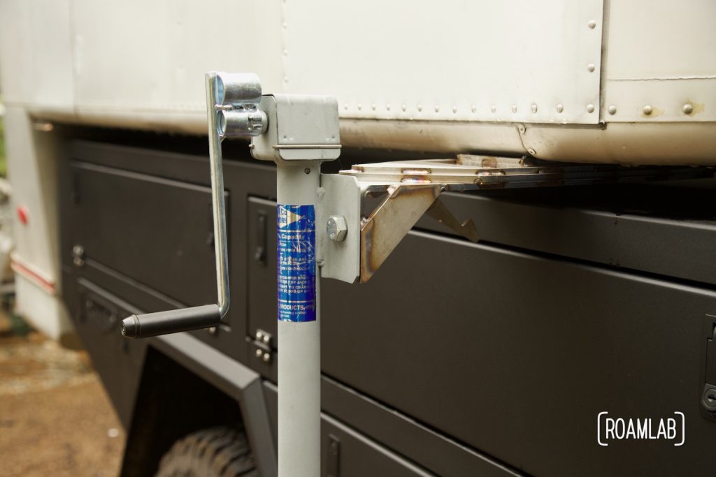 Jack connected to an aluminum truck camper to lift the camper out of a truck bed.