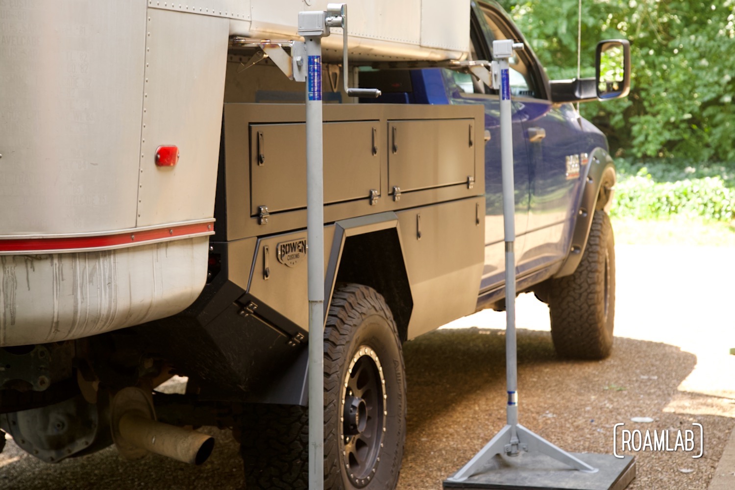 Truck camper lifted out of the truck bed with a set of jacks.