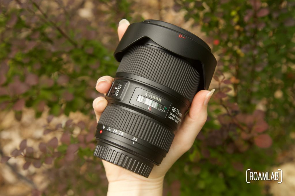 Hand holding a camera lens.