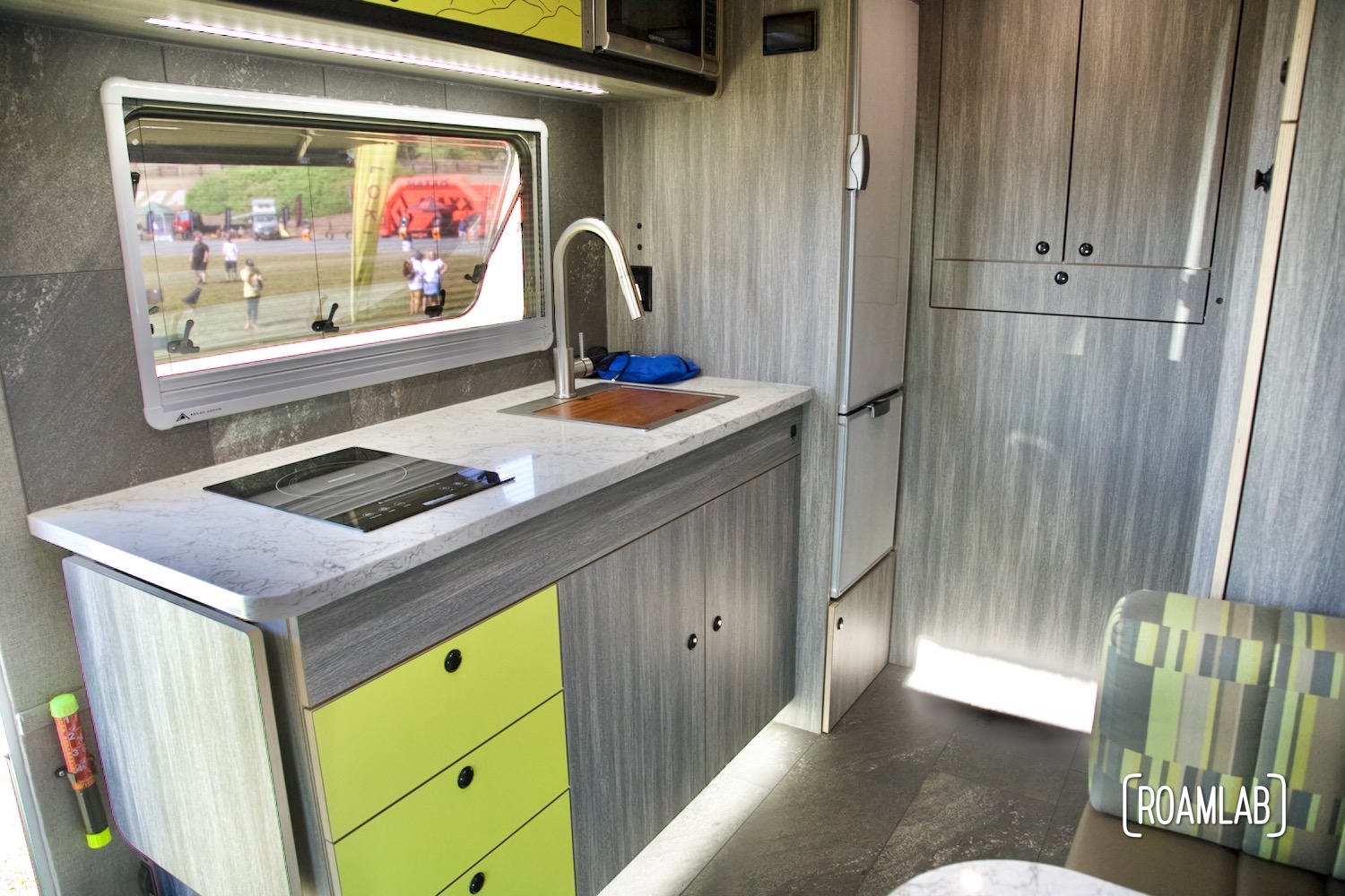 Grey and green camper kitchen interior on display.