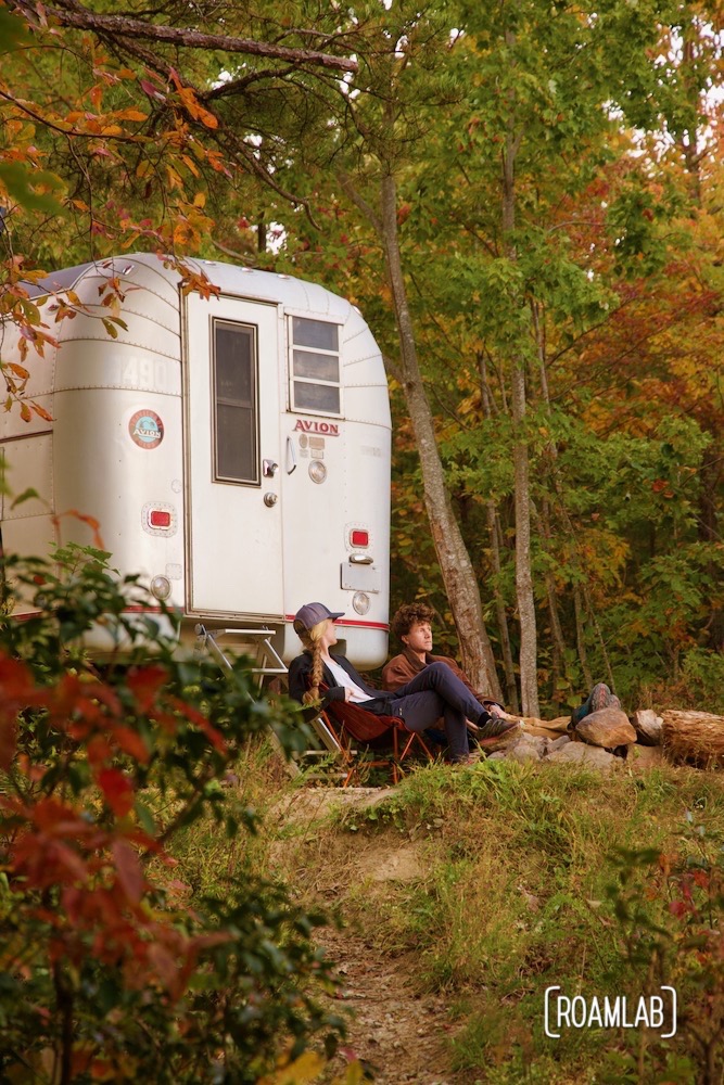 Couple sitting in camping chairs by their 1970 Avion C11 truck camper off Old North Carolina 105 in Linville Gorge Wilderness Area.