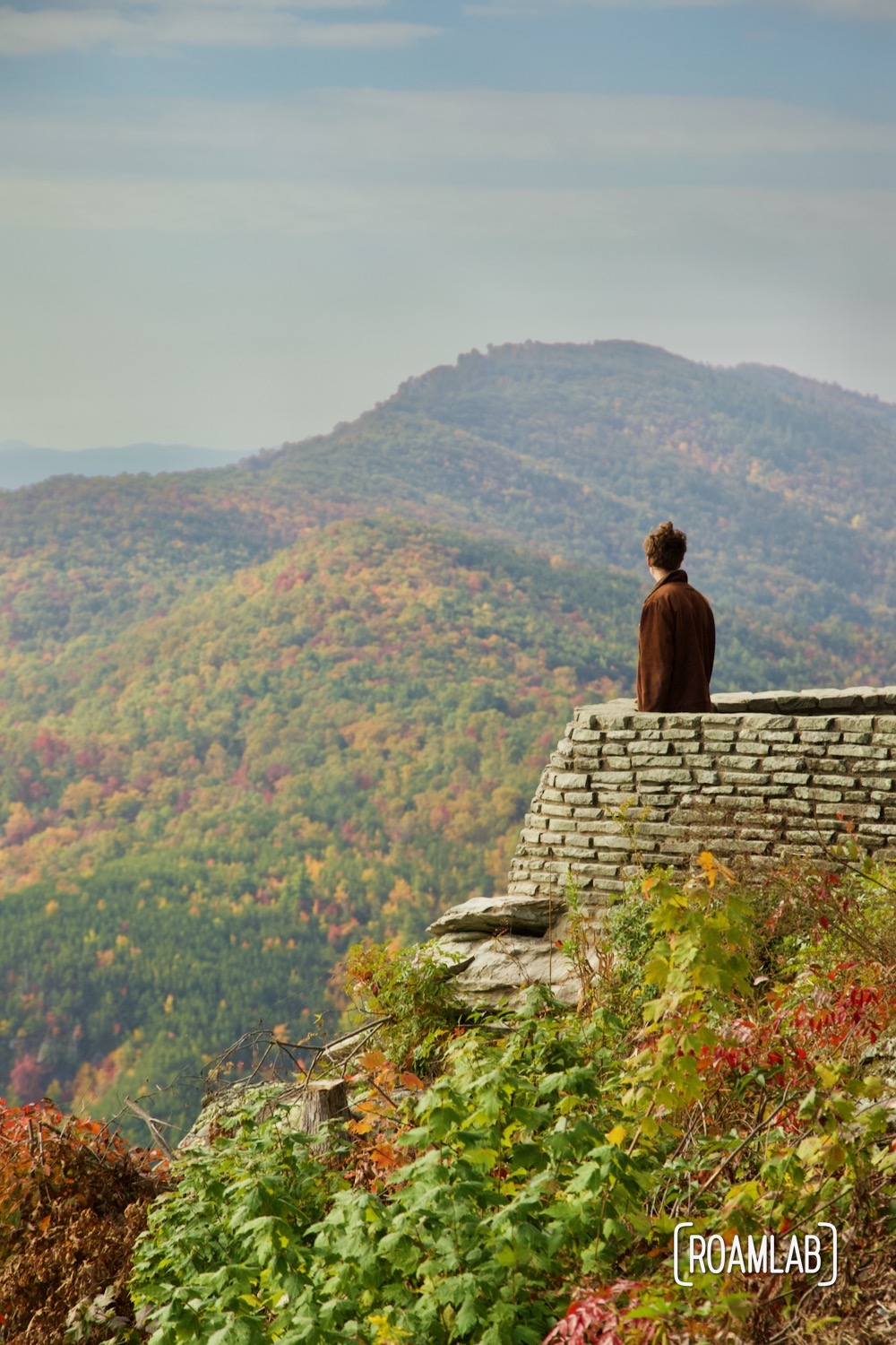 Man looking out over the fall colors of Linville Gorge Wilderness Area from Wiseman's View Scenic Overlook.