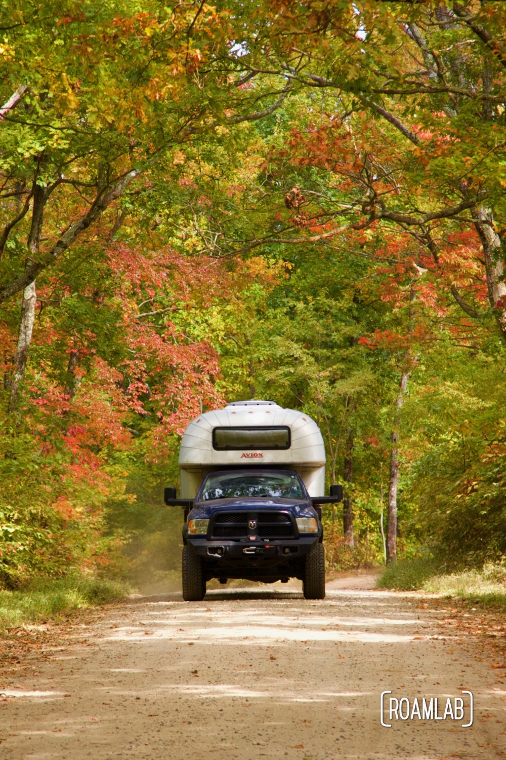 1970 Avion C11 truck camper surrounded by turning trees along Old North Carolina 105 in Linville Gorge Wilderness Area.