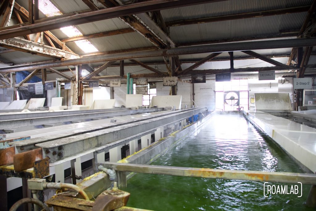 Perspective view down a tank of ripply greenish liquid with "gold dye" labeled above.