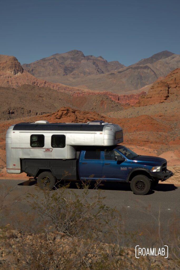 Avion C11 truck camper parked by a vista of red rock formations  and desert mountains in Lake Mead National Recreation Area outside Las Vegas, Nevada.